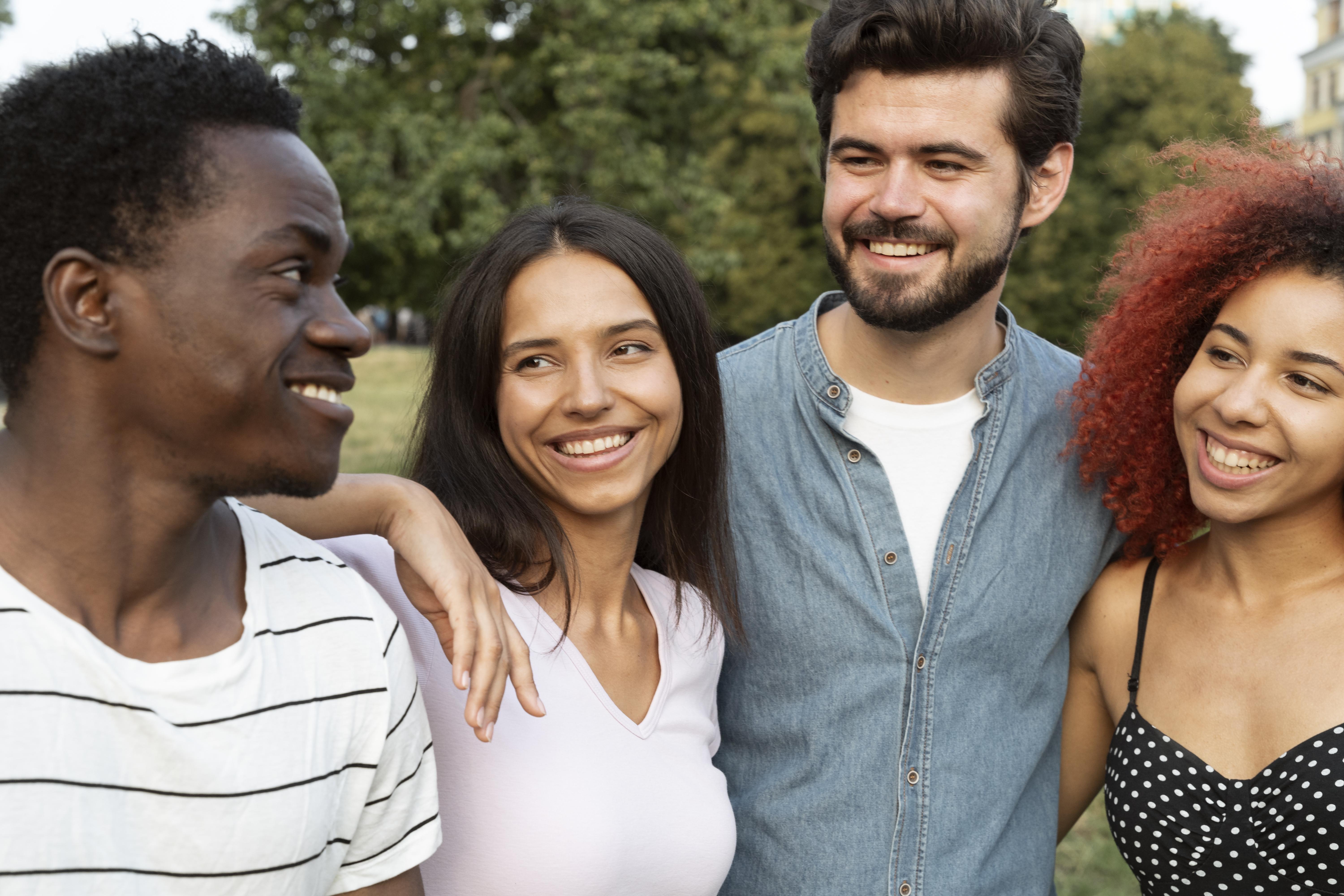 A diverse group of people in a support group, smiling and connecting.